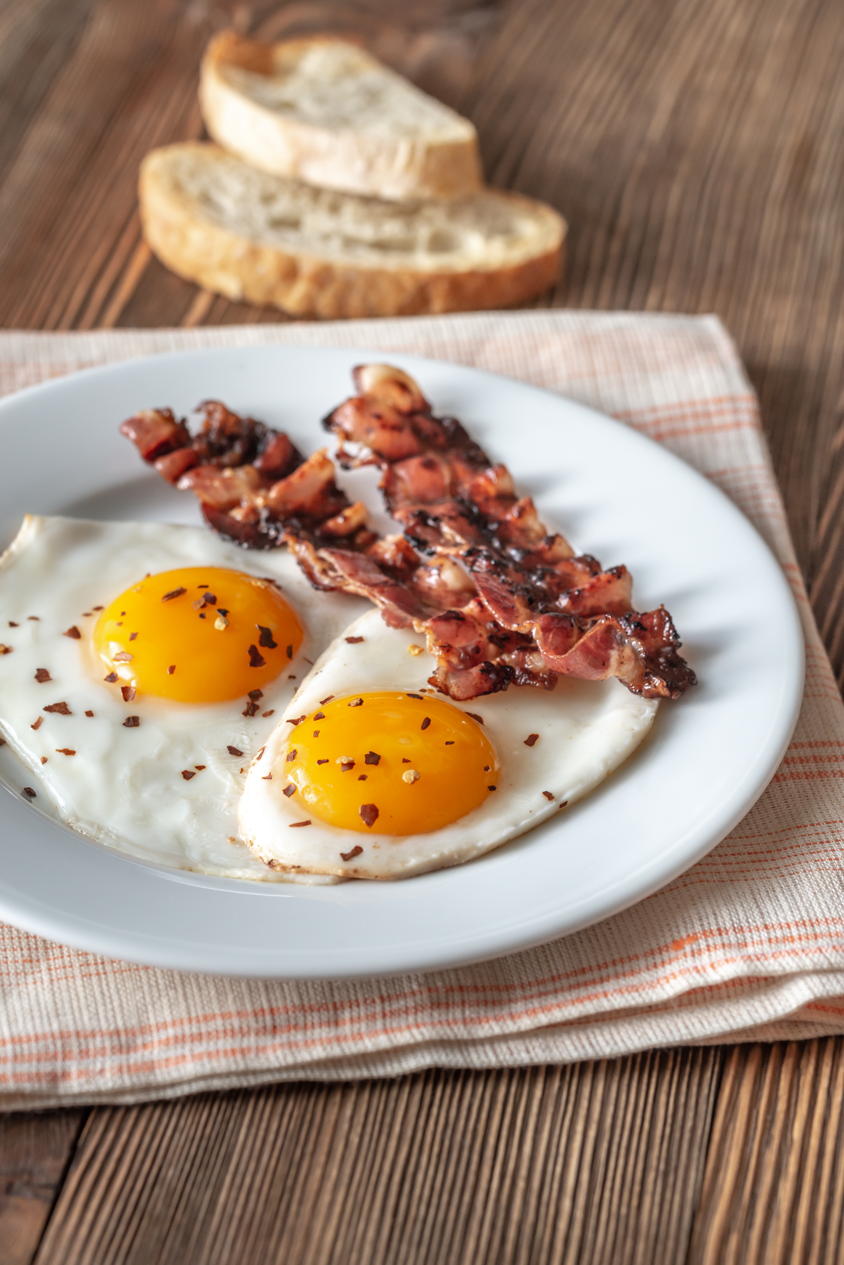 fried-eggs-and-bacon-on-the-white-plate-2023-11-27-05-02-37-utc.jpg